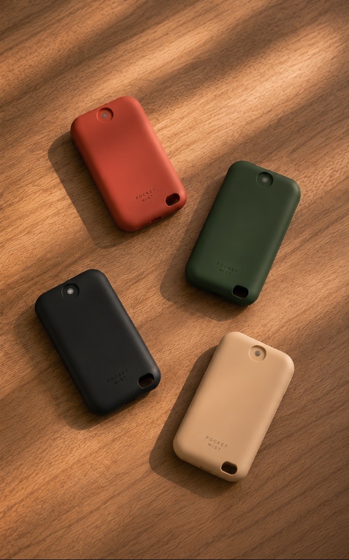 Four Pocket Mist devices arranged on a warm wooden table